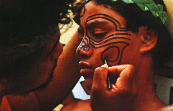 A Maori gets his face tatooed with paint